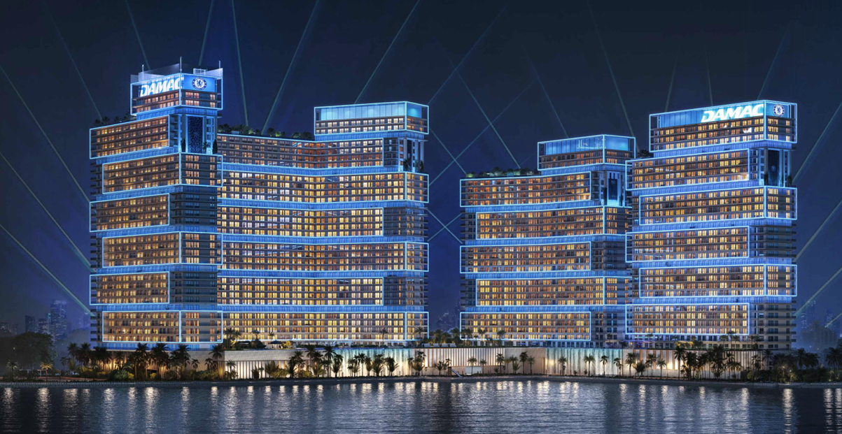 Les tours de Chelsea Residences by DAMAC illuminées de nuit face à la mer